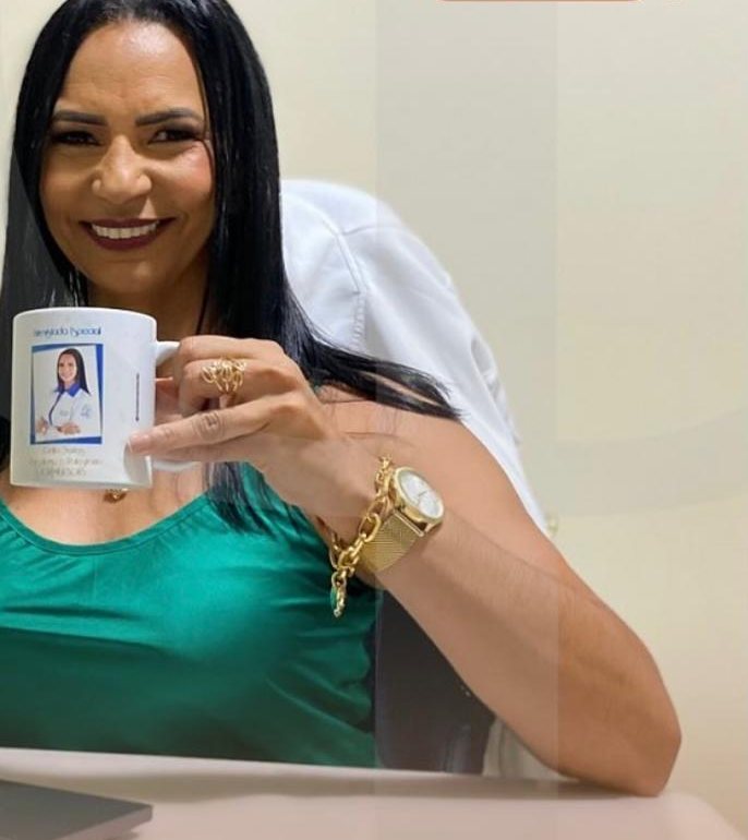 Celia Santos em atendimento on-line, com uma caneca e o notebook